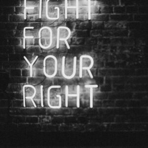 Monochrome neon sign on brick wall with slogan 'Fight for Your Right.' Perfect for motivation and urban themes.